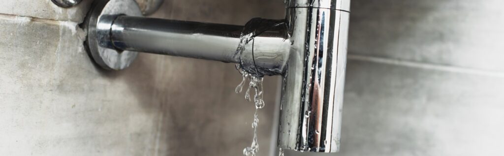 Damaged steel pipe with water drops on grey background